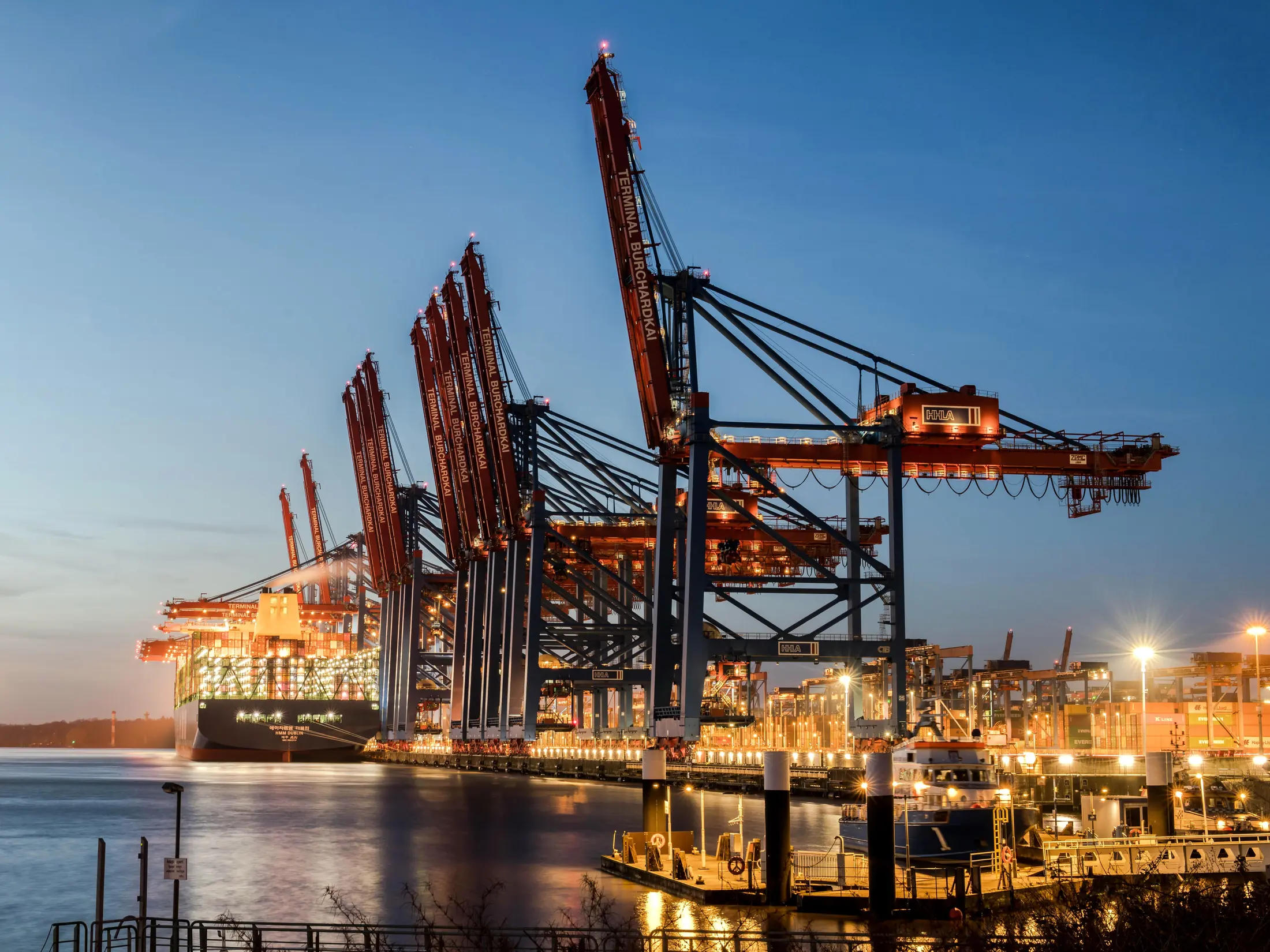 Container terminal gantry cranes lit at blue hour